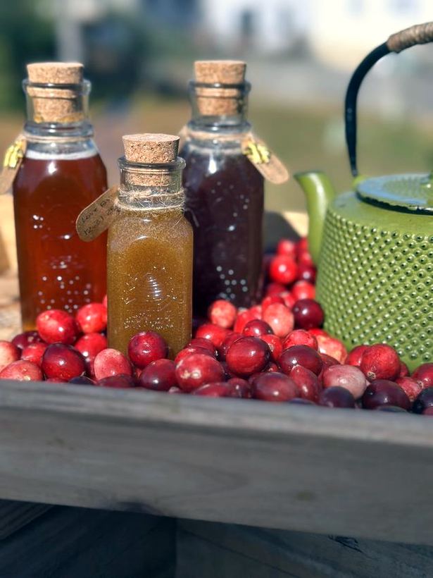 Honey bottles with cranberries and a teapot