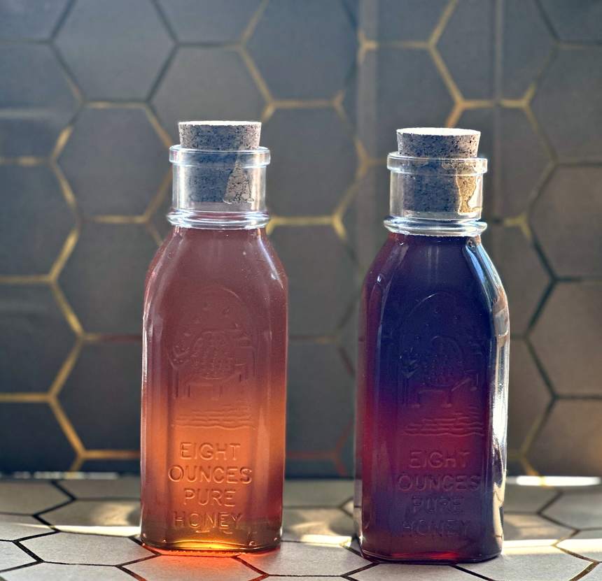 Two bottles of raw honey side by side